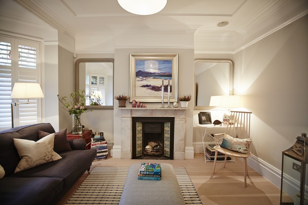 Klassisches Wohnzimmer mit grauer Wandfarbe, hellem Holzboden und Kamin in Sussex