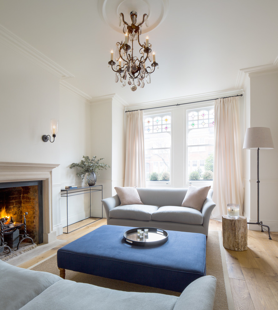 ロンドンにある高級な中くらいなトランジショナルスタイルのおしゃれな応接間 (標準型暖炉、白い壁、淡色無垢フローリング、テレビなし、ベージュの床) の写真