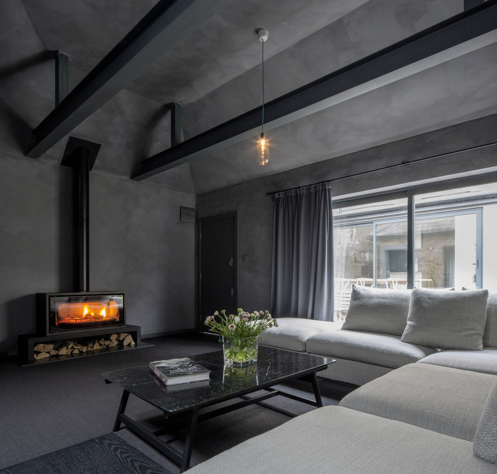 Idées déco pour un grand salon contemporain avec un mur gris, un poêle à bois, un sol gris et moquette.