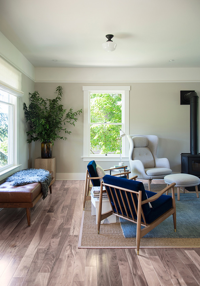 Пример оригинального дизайна: маленькая открытая гостиная комната в скандинавском стиле с серыми стенами, светлым паркетным полом, печью-буржуйкой, фасадом камина из камня и бежевым полом для на участке и в саду