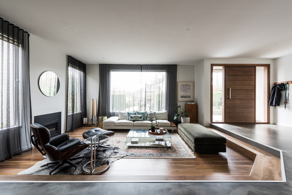 Immagine di un grande soggiorno minimal aperto con pareti bianche, pavimento in cemento, nessun camino, parete attrezzata e pavimento grigio