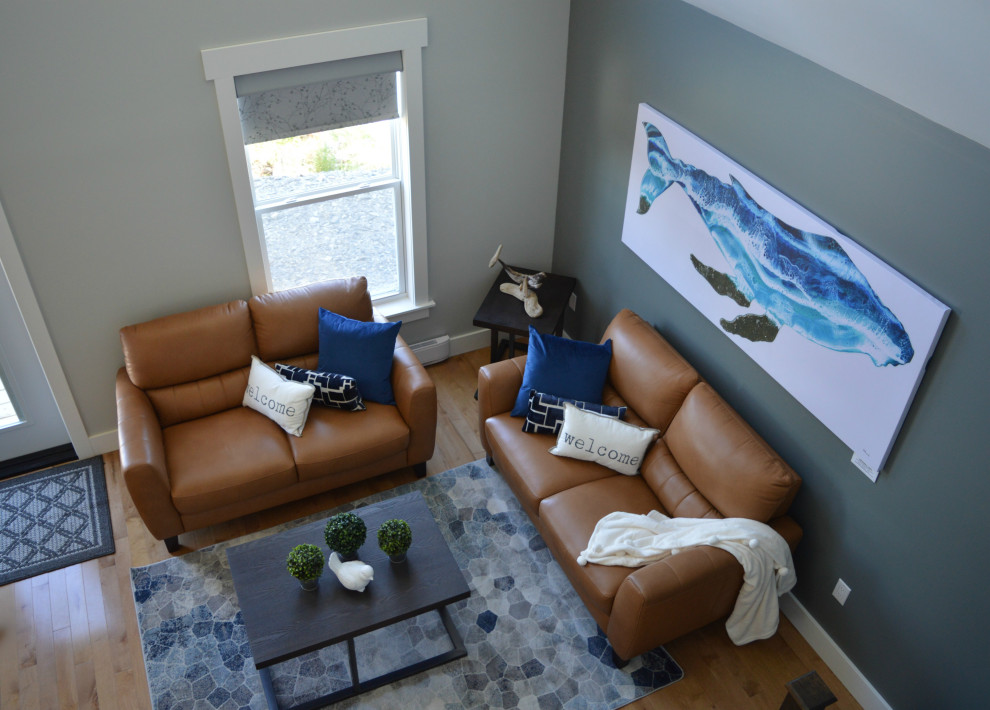 This is an example of a medium sized coastal open plan living room in Other with grey walls, light hardwood flooring, a vaulted ceiling and beige floors.