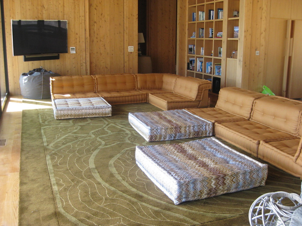 На фото: большая открытая гостиная комната в стиле модернизм с светлым паркетным полом, двусторонним камином, фасадом камина из камня и телевизором на стене