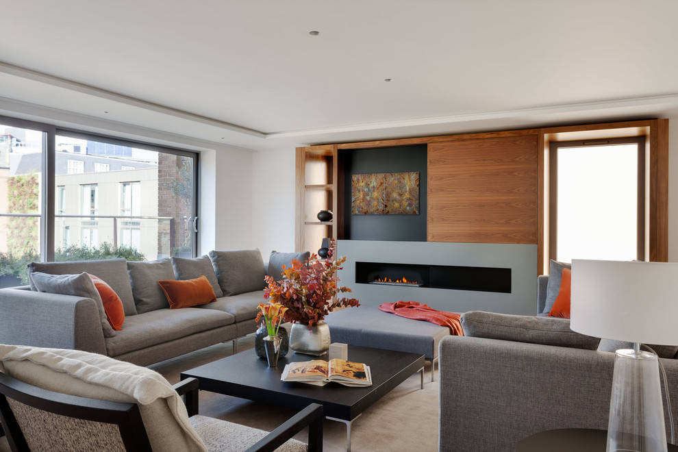 Large contemporary enclosed living room in London with white walls, light hardwood flooring, a ribbon fireplace, a built-in media unit and feature lighting.
