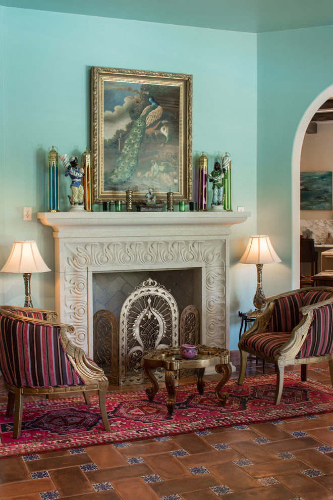 Repräsentatives, Fernseherloses Mediterranes Wohnzimmer mit blauer Wandfarbe, Kamin und Terrakottaboden in Houston