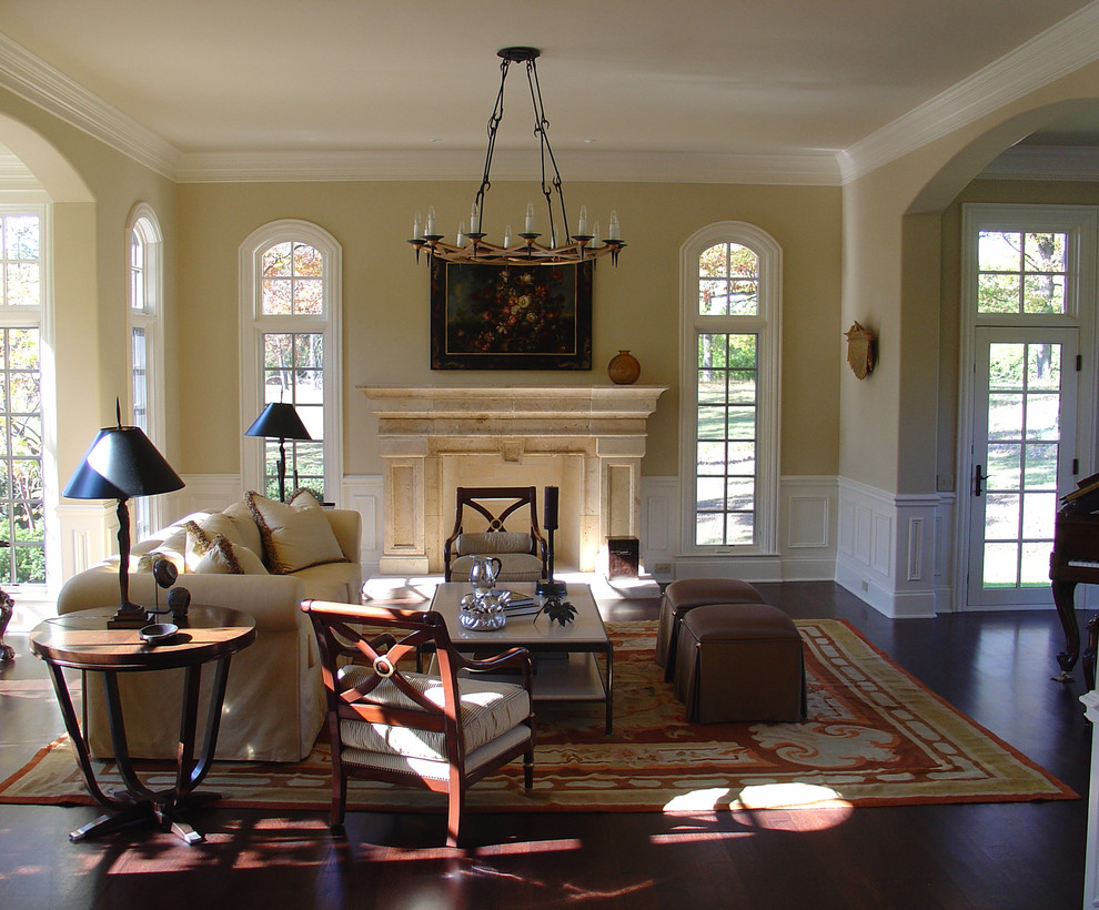 Repräsentatives Klassisches Wohnzimmer mit beiger Wandfarbe, dunklem Holzboden, Kamin und Kaminumrandung aus Stein in Chicago