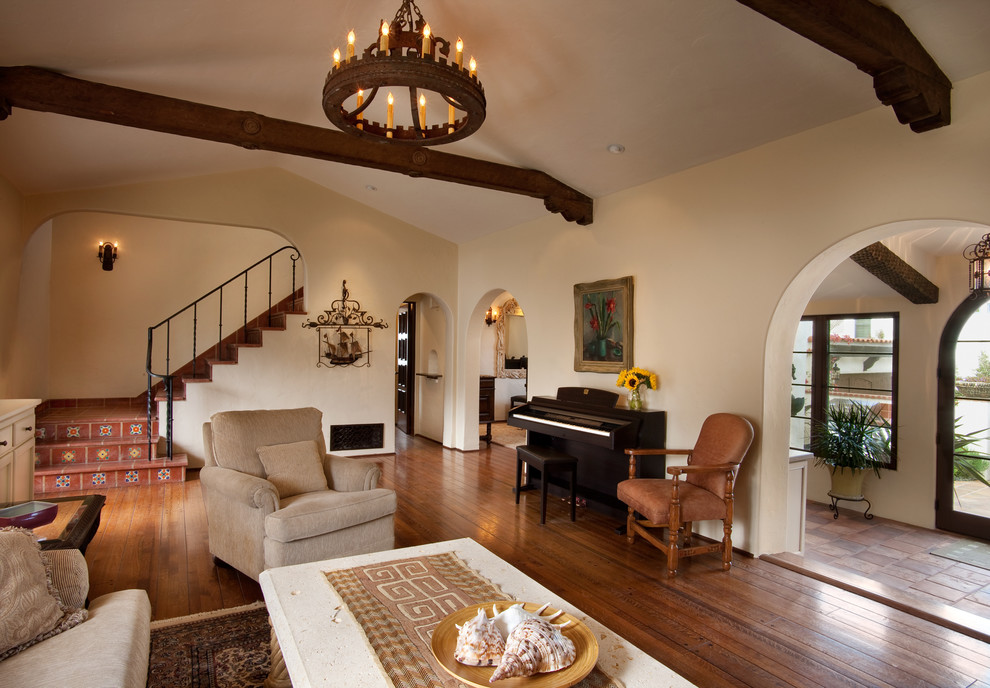 Tuscan medium tone wood floor living room photo in San Diego with beige walls