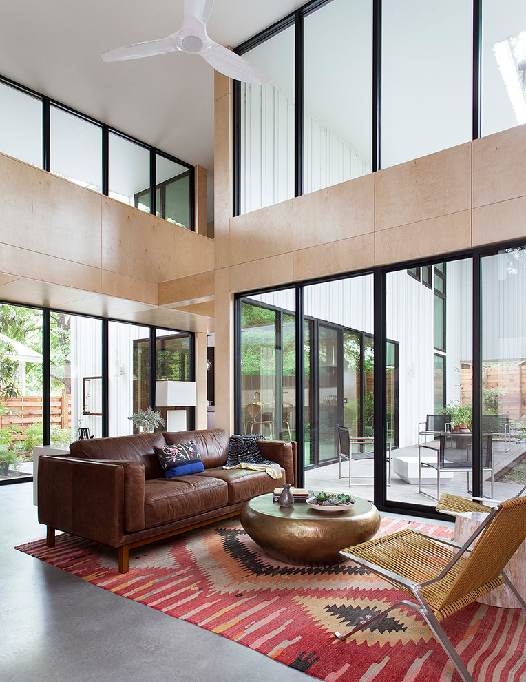 Стильный дизайн: парадная, открытая гостиная комната в стиле ретро с бетонным полом и ковром на полу - последний тренд