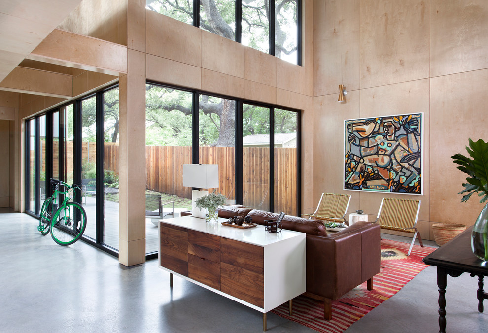 Offenes, Großes, Repräsentatives, Fernseherloses Modernes Wohnzimmer ohne Kamin mit Betonboden, brauner Wandfarbe und grauem Boden in Austin