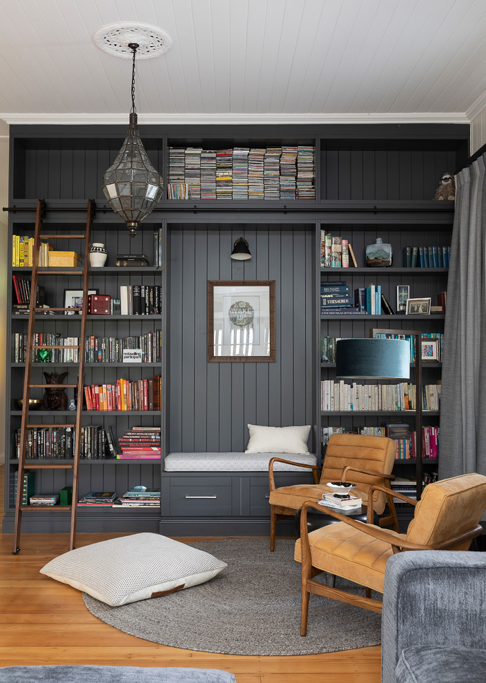 Imagen de biblioteca en casa cerrada, clásica renovada, con paredes blancas, suelo de madera en tonos medios y suelo marrón