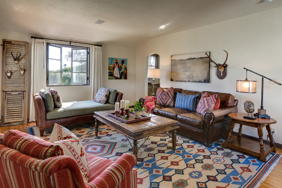 Abgetrenntes, Mittelgroßes, Fernseherloses Mediterranes Wohnzimmer ohne Kamin mit weißer Wandfarbe, braunem Holzboden und braunem Boden in Orange County