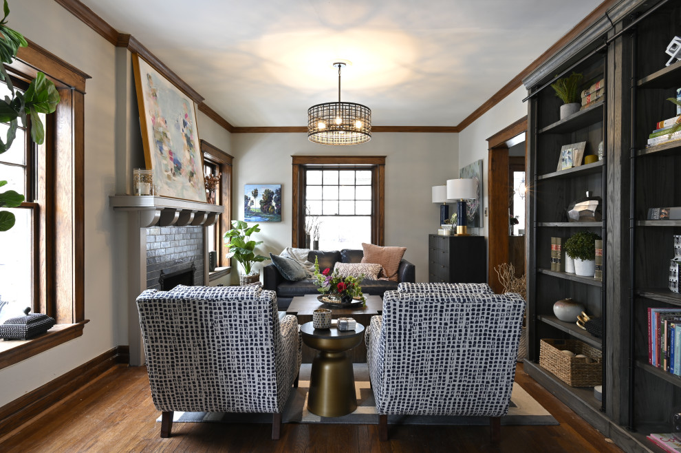 Стильный дизайн: гостиная комната в стиле неоклассика (современная классика) с серыми стенами, темным паркетным полом, стандартным камином, фасадом камина из кирпича и коричневым полом - последний тренд