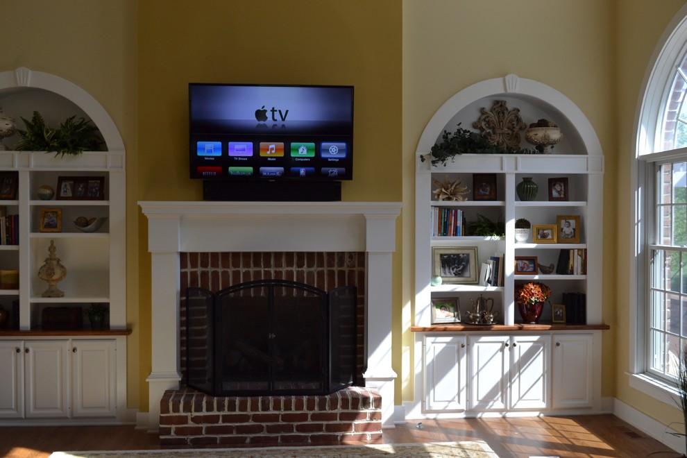 Idéer för stora vintage allrum med öppen planlösning, med gula väggar, mellanmörkt trägolv, en standard öppen spis och en väggmonterad TV