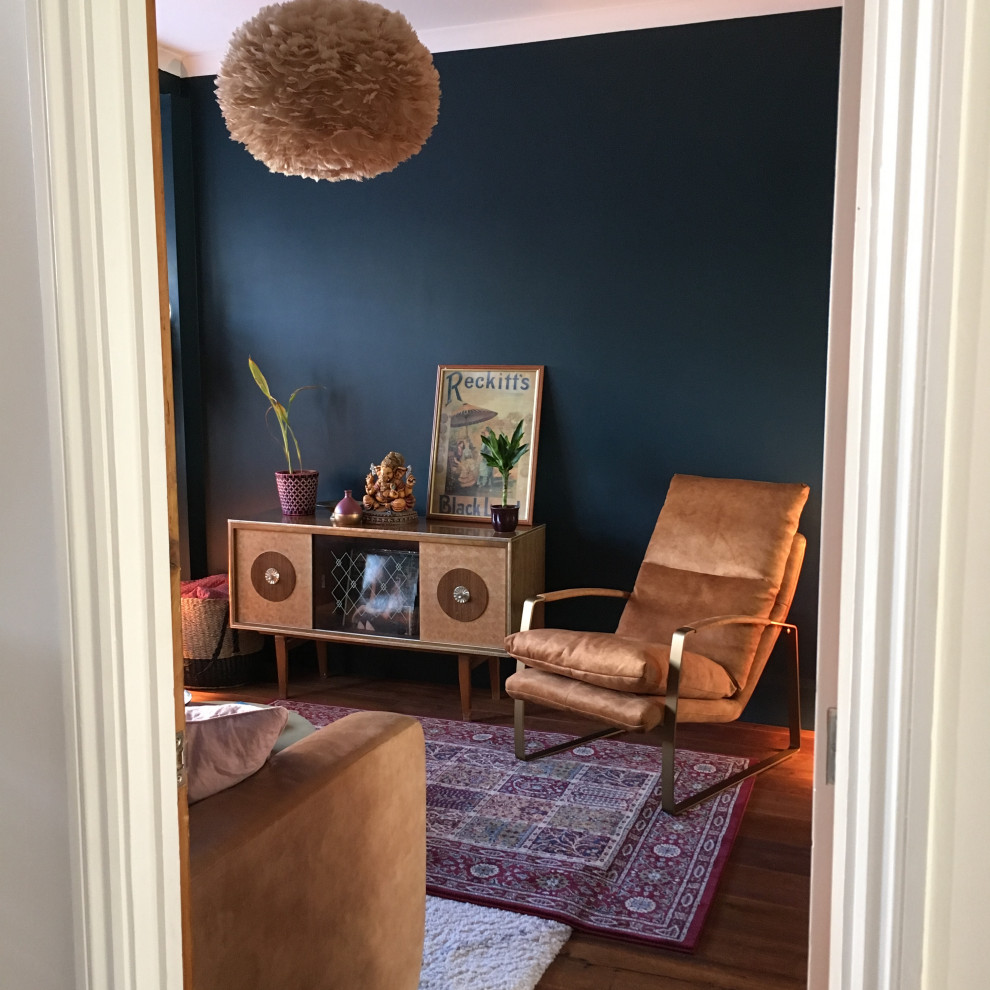 Foto de salón abierto vintage de tamaño medio sin televisor con paredes azules, chimenea de doble cara, marco de chimenea de ladrillo y suelo marrón