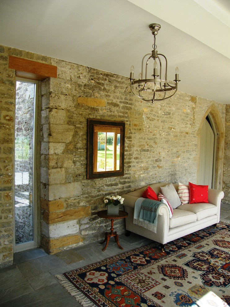 Landhausstil Wohnzimmer mit beiger Wandfarbe, Schieferboden und Steinwänden in Dorset