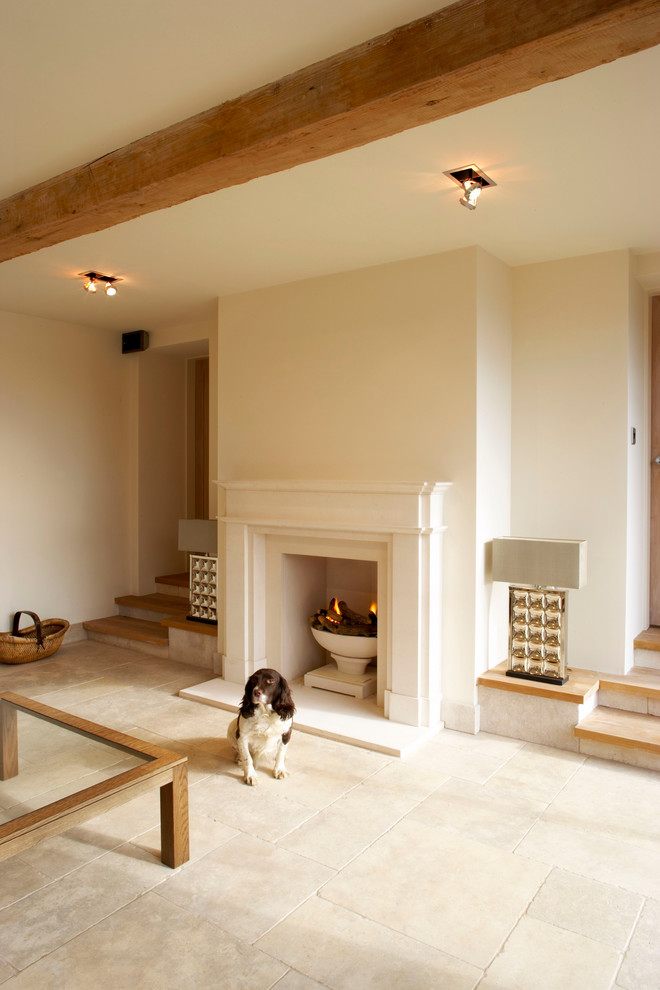 Foto de salón tradicional renovado extra grande con paredes beige, suelo de piedra caliza y marco de chimenea de piedra