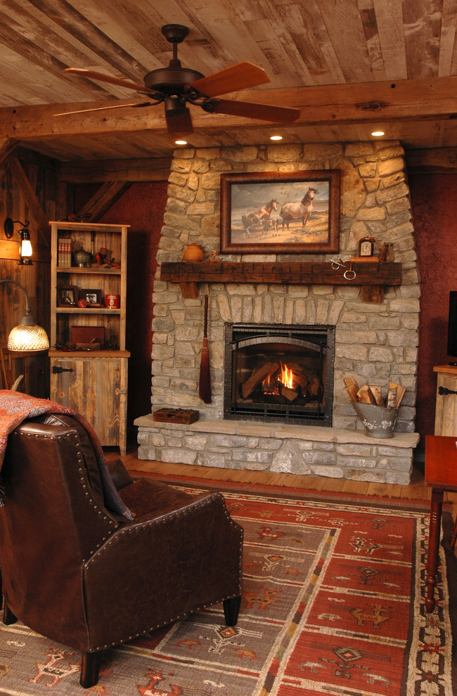 Idées déco pour un salon montagne de taille moyenne avec un mur rouge, un sol en bois brun, une cheminée standard et un manteau de cheminée en pierre.