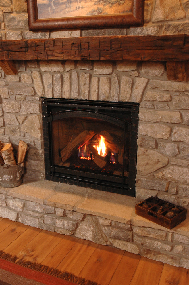 シンシナティにあるラスティックスタイルのおしゃれなリビング (無垢フローリング、標準型暖炉、石材の暖炉まわり) の写真