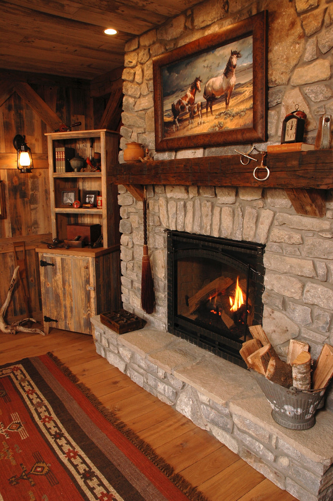 Modelo de salón rural de tamaño medio con paredes rojas, suelo de madera en tonos medios, todas las chimeneas y marco de chimenea de piedra