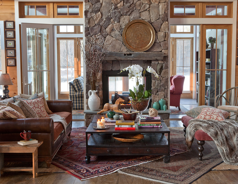 На фото: гостиная комната в классическом стиле с двусторонним камином и фасадом камина из камня