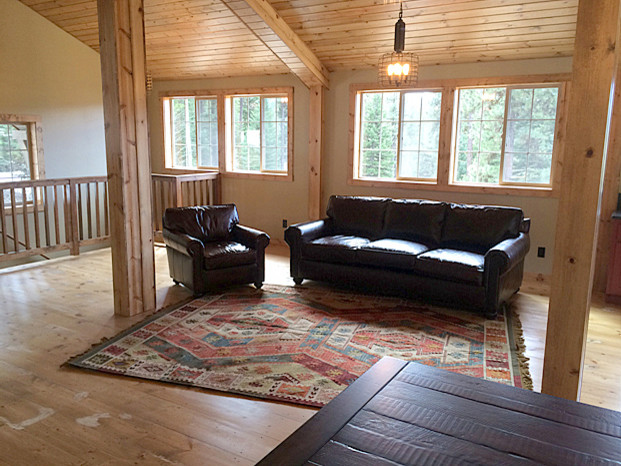 Foto de salón tipo loft rústico de tamaño medio con suelo de madera clara, estufa de leña y televisor independiente