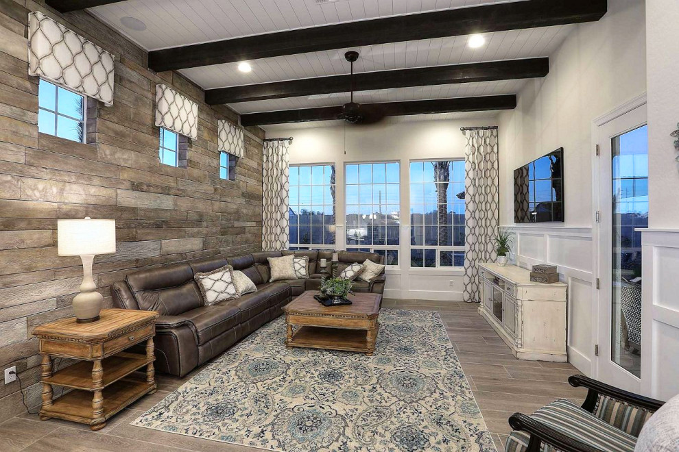 Inspiration for a large farmhouse open plan living room in Phoenix with beige walls, porcelain flooring, no fireplace, a wall mounted tv and brown floors.