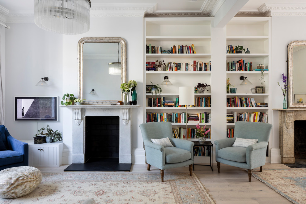 Imagen de biblioteca en casa abierta clásica renovada de tamaño medio con paredes grises, suelo de madera clara, suelo beige, todas las chimeneas y marco de chimenea de piedra