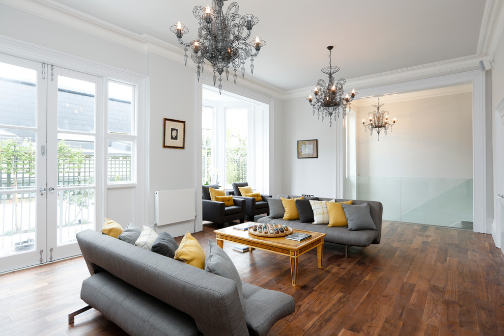 This is an example of a contemporary grey and yellow living room in Surrey with white walls.