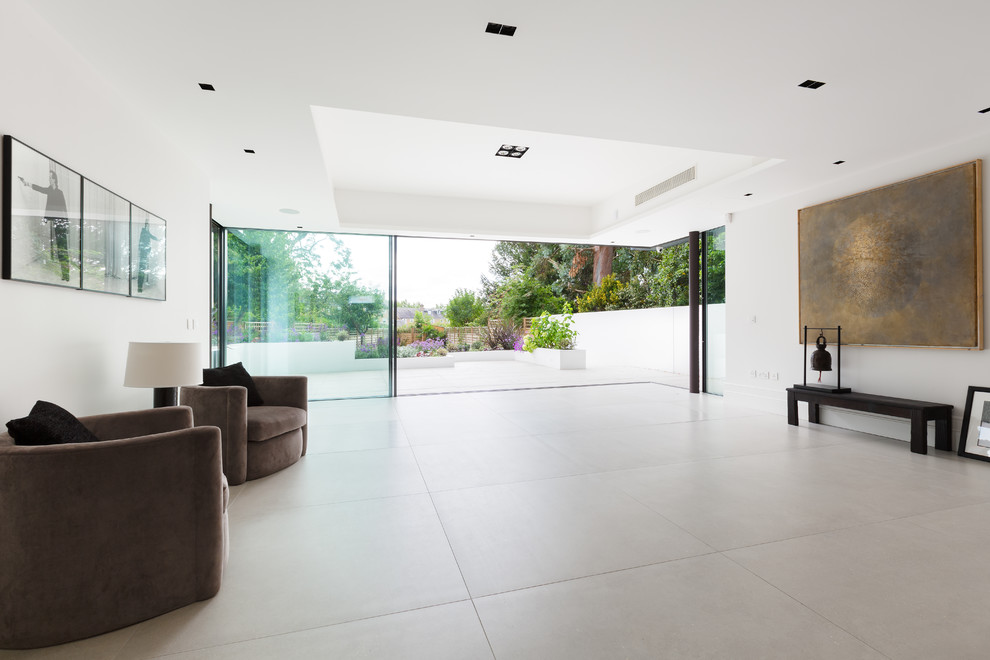Ispirazione per un grande soggiorno design aperto con pareti bianche, pavimento in gres porcellanato e pavimento grigio