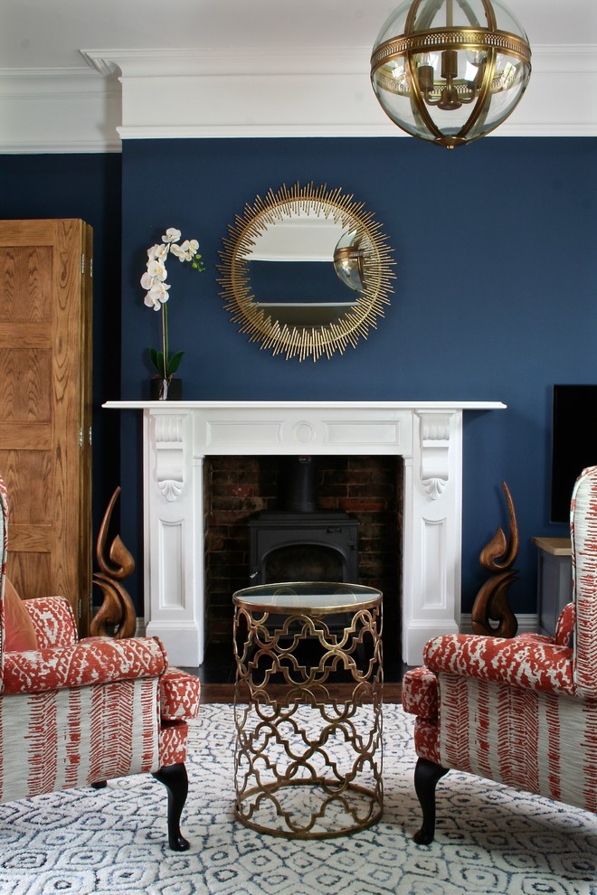 Esempio di un grande soggiorno chic aperto con pareti blu, pavimento in legno massello medio, stufa a legna, cornice del camino in legno e pavimento marrone