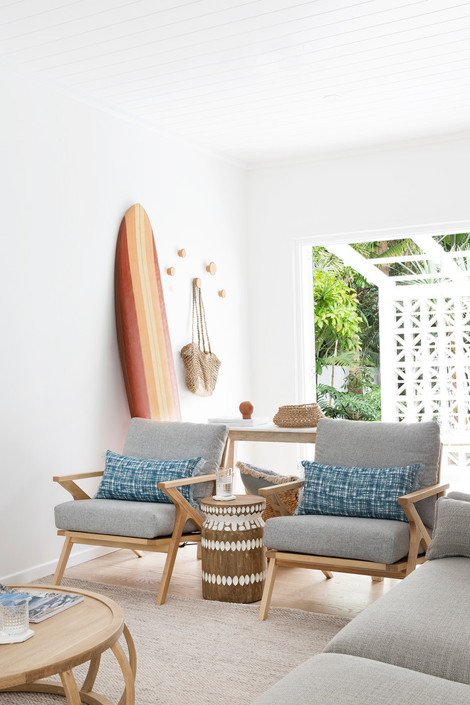 Maritimes Wohnzimmer mit weißer Wandfarbe, braunem Holzboden und braunem Boden in Brisbane
