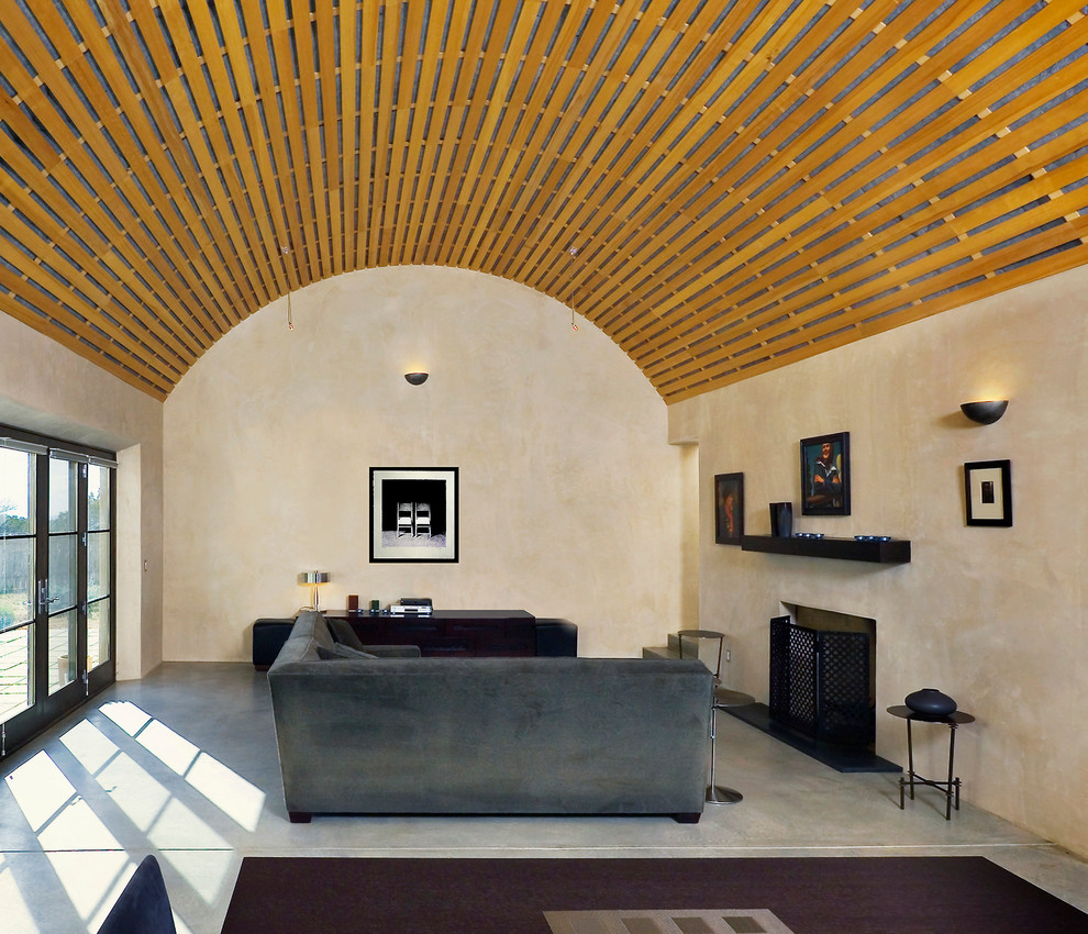 Foto de salón actual con paredes beige, suelo de cemento y todas las chimeneas