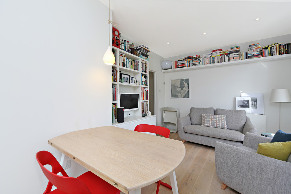 Living room library - small scandinavian open concept light wood floor living room library idea in London with white walls, no fireplace and a wall-mounted tv