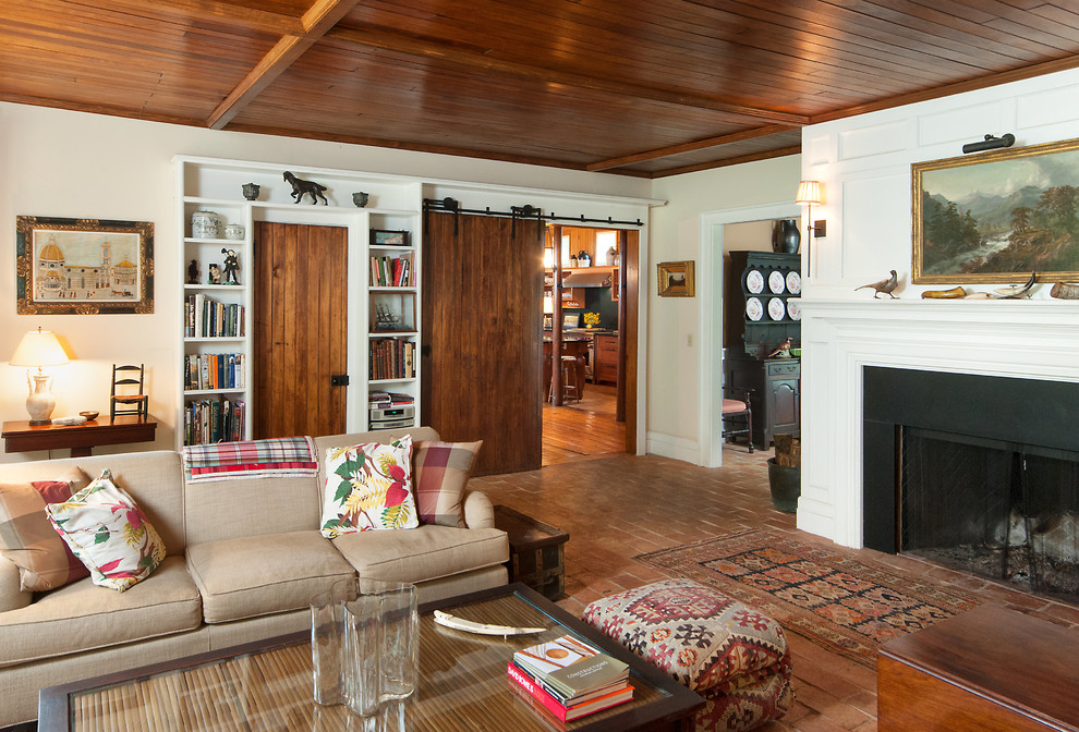 Example of a large farmhouse enclosed ceramic tile and red floor living room design in New York with beige walls, a standard fireplace, a stone fireplace and no tv