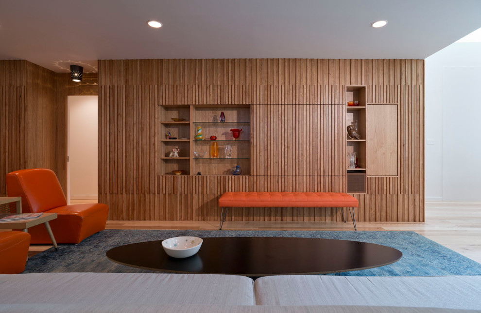 Esempio di un grande soggiorno minimalista aperto con sala formale, pareti marroni, parquet chiaro, nessun camino, TV nascosta, pavimento marrone e pareti in legno