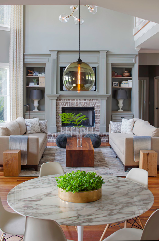 This is an example of a large contemporary open plan living room in Atlanta with grey walls, medium hardwood flooring, a standard fireplace and a brick fireplace surround.