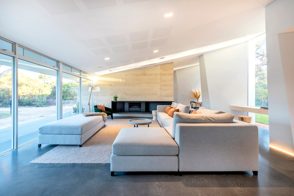 Идея дизайна: открытая гостиная комната в современном стиле с белыми стенами, бетонным полом, горизонтальным камином и серым полом