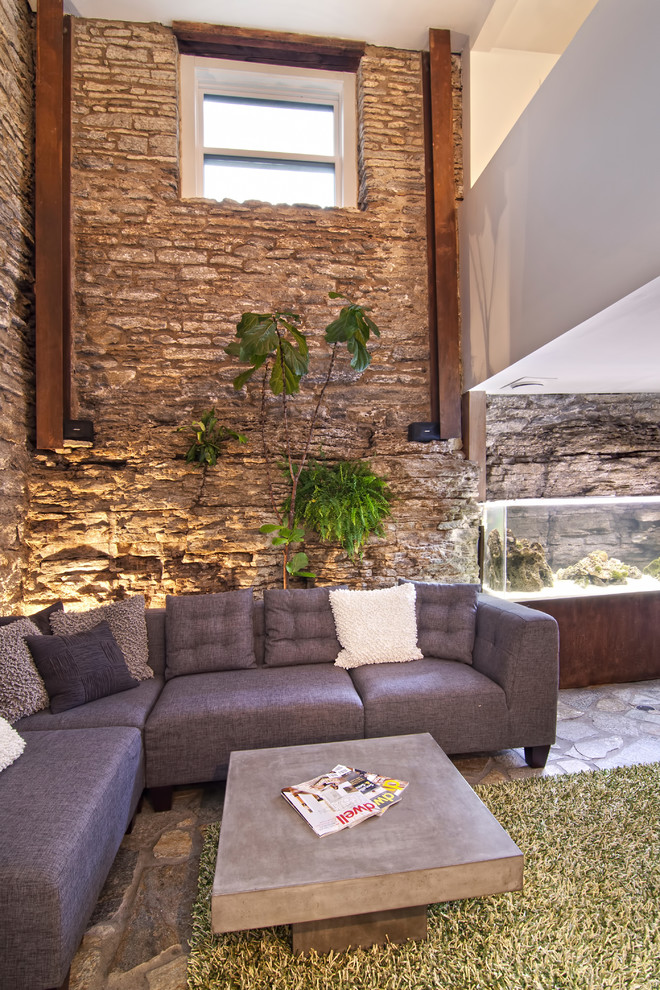Idée de décoration pour un salon design avec un mur beige et un mur en pierre.