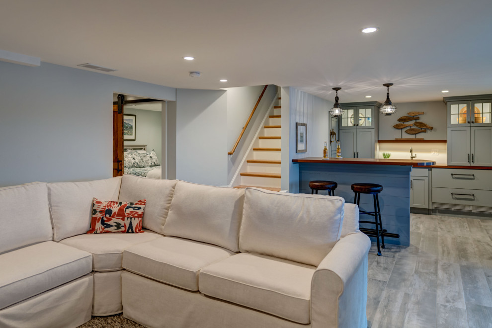 Exempel på ett mellanstort klassiskt allrum med öppen planlösning, med en hemmabar, blå väggar, klinkergolv i porslin, en fristående TV och grått golv