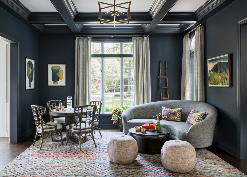 Cette image montre un salon bohème fermé avec un mur bleu et parquet foncé.