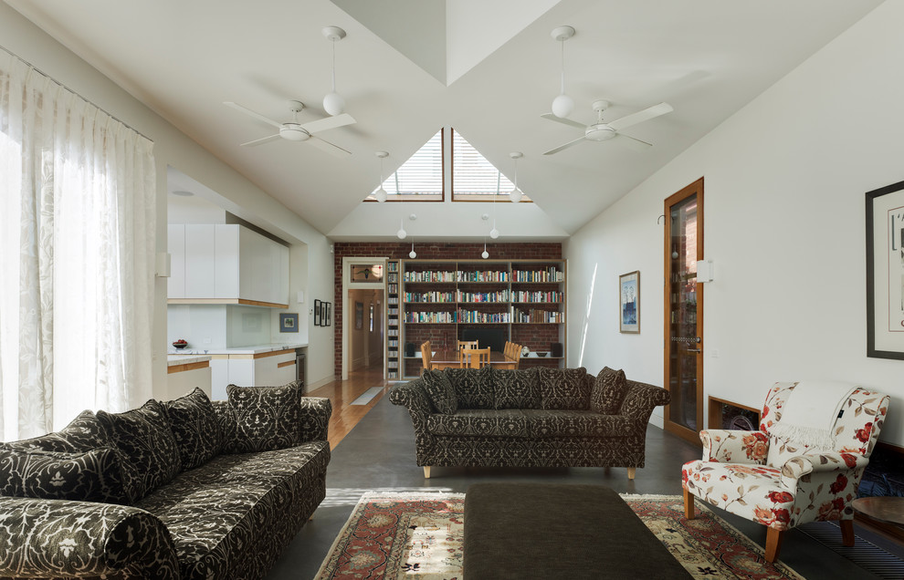 Foto di un grande soggiorno minimal aperto con libreria, pareti bianche, pavimento in cemento e nessun camino