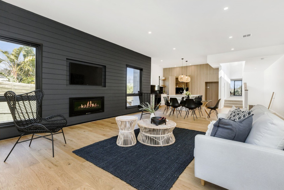 Großes, Offenes Modernes Wohnzimmer mit grauer Wandfarbe, hellem Holzboden, Kamin, verputzter Kaminumrandung und Multimediawand in Melbourne