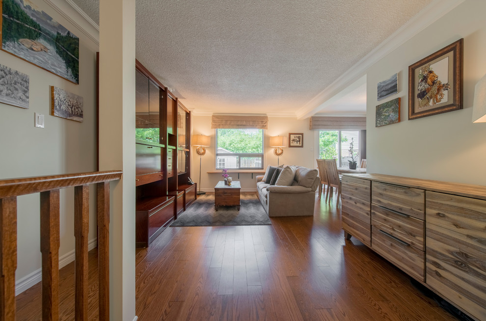 Foto di un soggiorno classico di medie dimensioni e aperto con pareti beige, pavimento in legno massello medio, nessun camino e pavimento marrone