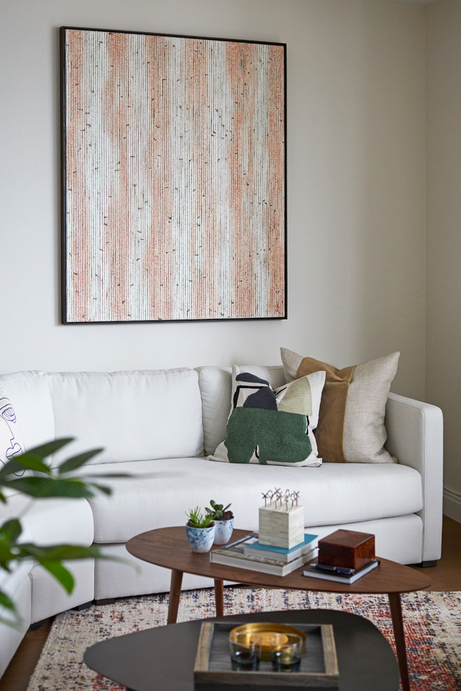 Ispirazione per un soggiorno minimalista di medie dimensioni e aperto con pareti beige, pavimento in legno massello medio, TV autoportante e pavimento marrone