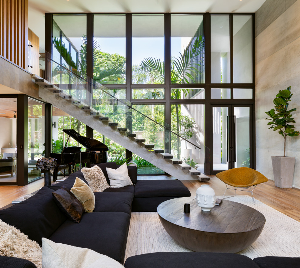 Immagine di un soggiorno contemporaneo aperto con pareti beige, pavimento in legno massello medio e pavimento marrone