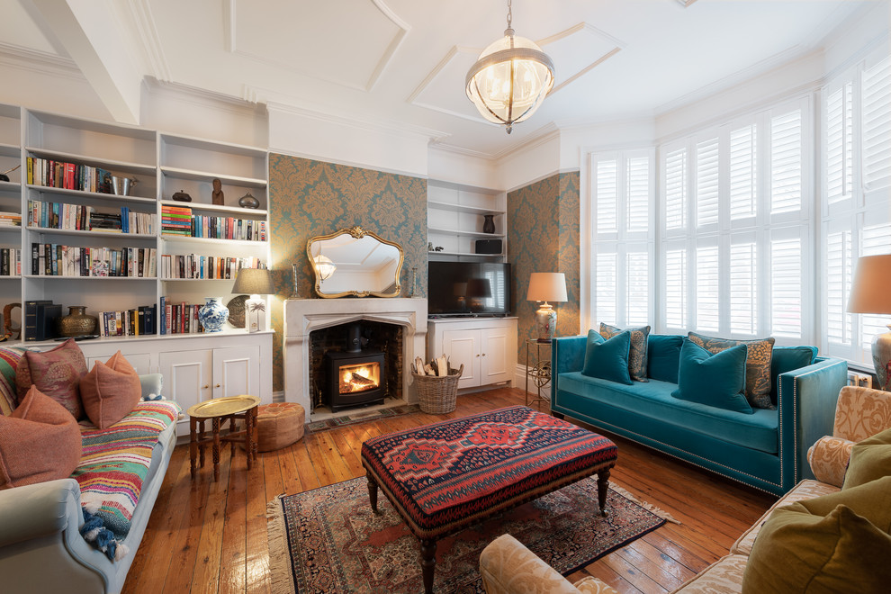 Immagine di un soggiorno chic di medie dimensioni con pareti bianche, pavimento in legno massello medio, stufa a legna e pavimento marrone
