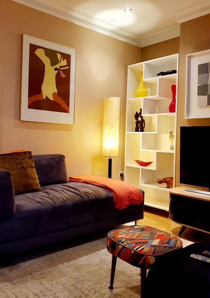 Modelo de salón abierto bohemio de tamaño medio con paredes marrones, suelo de madera en tonos medios, televisor independiente y suelo marrón