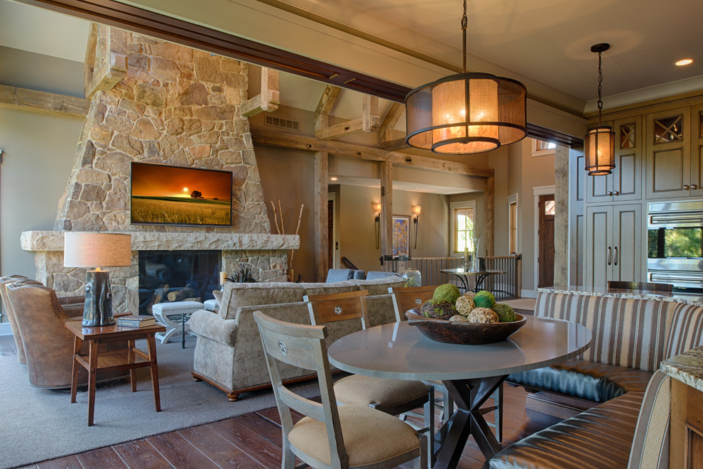 Inspiration for a mid-sized rustic formal and open concept dark wood floor and brown floor living room remodel in Minneapolis with beige walls, a standard fireplace, a stone fireplace and a wall-mounted tv