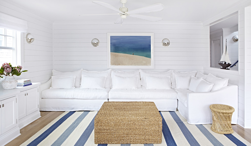 Immagine di un piccolo soggiorno stile marino aperto con pareti bianche, parquet chiaro e nessun camino