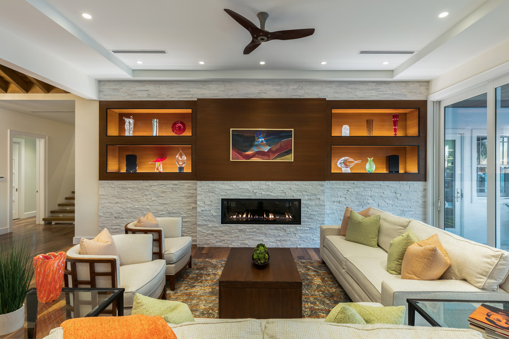 タンパにある高級な中くらいなトランジショナルスタイルのおしゃれなLDK (白い壁、無垢フローリング、横長型暖炉、石材の暖炉まわり、テレビなし、茶色い床) の写真